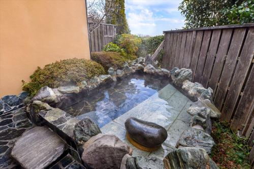 a small pond with rocks in a garden at Hanare Yado Yosizumi in Ito