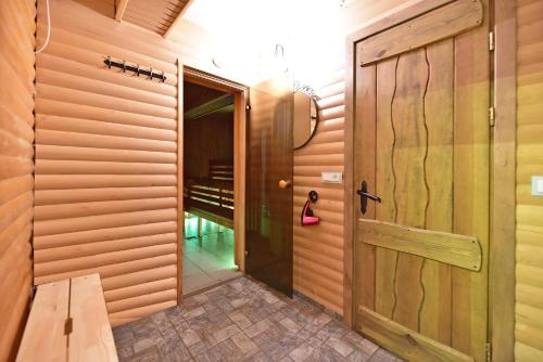 a hallway with a wooden door and a walk in closet at Pundeliškių sodyba in Skynimai
