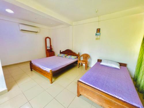 1 Schlafzimmer mit 2 Betten in einem Zimmer in der Unterkunft Touch Down Family Restaurant & hotel in Katunayaka