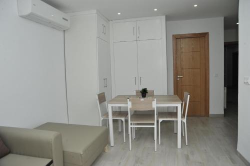 - une salle à manger avec une table, des chaises et une porte dans l'établissement KANTAOUI RESIDENCE REMY, à Hammam Sousse