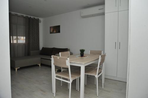 - une table à manger blanche avec des chaises et un canapé dans l'établissement KANTAOUI RESIDENCE REMY, à Hammam Sousse