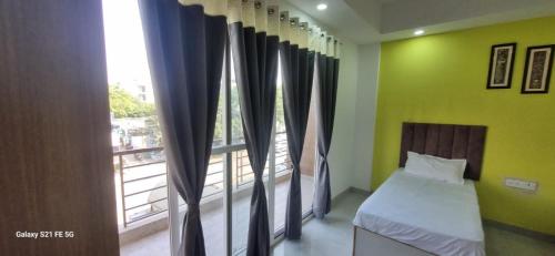 a bedroom with a bed and a large window at Happy Living in Noida