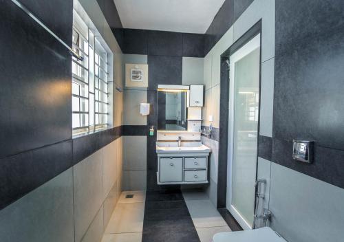 a bathroom with a sink and a mirror at Kanavu Valley View Premium 4 Star Resort Ooty by VOYE HOMES in Ooty