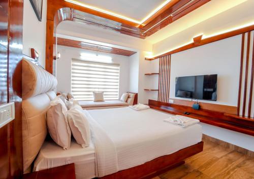 1 dormitorio con 1 cama grande y TV en Kanavu Valley View Premium 4 Star Resort Ooty by VOYE HOMES, en Ooty