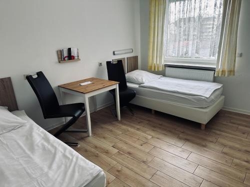 a room with a desk and a bed and a table at Gästehaus Hanseat in Bremerhaven