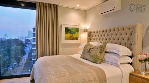 une chambre avec un lit avec une grande fenêtre dans l'établissement Luxury apartments - Greenpoint - 35 on Main, au Cap