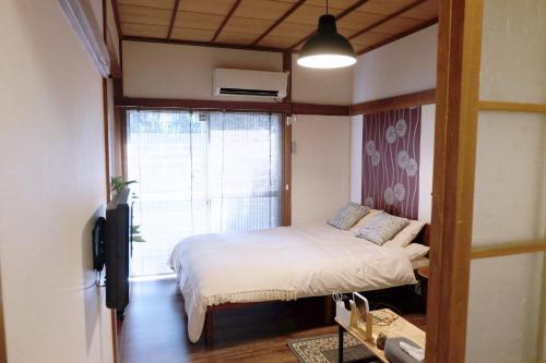 Habitación pequeña con cama y ventana en green park heights - Vacation STAY 15683 en Musashino