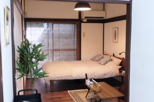 um quarto com uma cama e uma grande janela em green park heights - Vacation STAY 15684 em Musashino