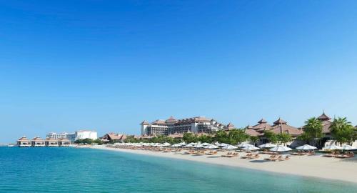 a beach with chairs and umbrellas and a resort at Royal Amwaj Apartments, Palm Jumeirah, Free beach and pool access in Dubai