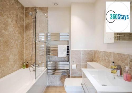 a bathroom with a shower and a toilet and a sink at Luxury 1 Bedroom Apartment 06 with Parking in Maidenhead by 360stays in Maidenhead
