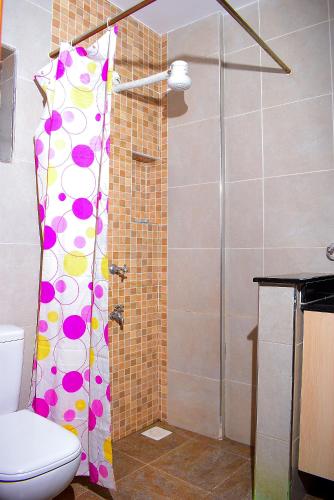 a shower curtain with polka dots on it in a bathroom at Luxxe Lofts-West Suites in Nairobi