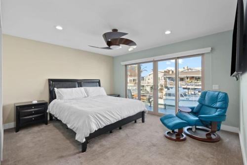 a bedroom with a bed and a blue chair at Voted Airbnb Most Loved Home 2024 Duffy Boat in Huntington Beach