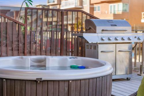 a hot tub and a grill on a deck at Voted Airbnb Most Loved Home 2024 Duffy Boat in Huntington Beach