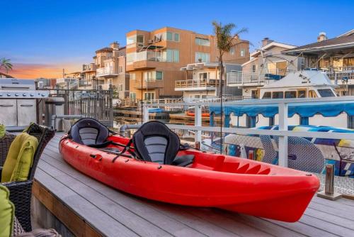 a red kayak sitting on a dock next to a pool at Voted Airbnb Most Loved Home 2024 Duffy Boat in Huntington Beach