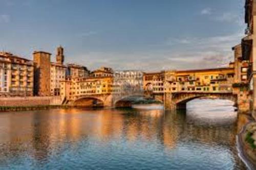 een brug over een rivier in een stad met gebouwen bij 4 bedrooms house with furnished terrace at Citta Metropolitana di Firenze in Compiobbi