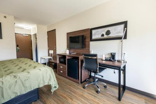 a hotel room with a desk and a bed at Quality Inn in Carrollton
