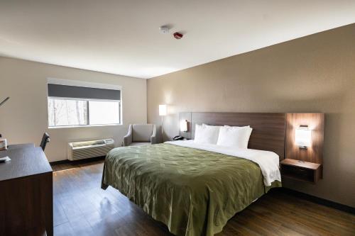 a hotel room with a large bed and a window at Quality Inn in Carrollton
