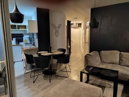 sala de estar y cocina con mesa y sofá en Apartment Triangle, en Divčibare
