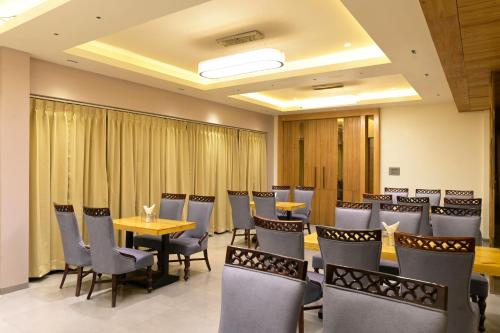 une salle de conférence avec des tables, des chaises et une table dans l'établissement Hotel Aditya Grand, à Bhopal