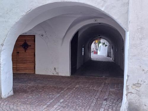an alley way with an archway in a building at Lanziner Apartments in Egna