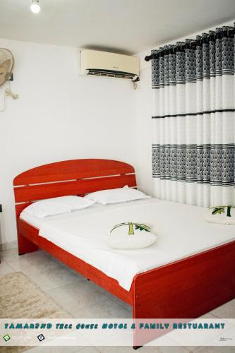 a bedroom with a bed and a curtain at Tamarind Tree House in Wellawaya