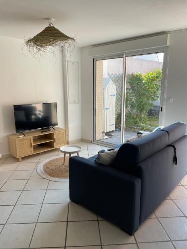 a living room with a couch and a tv at La Blériotine in Sangatte