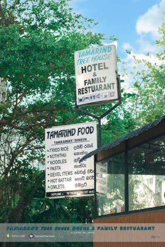 un panneau pour un hôtel et un panneau pour un restaurant familial dans l'établissement Tamarind Tree House, à Wellawaya