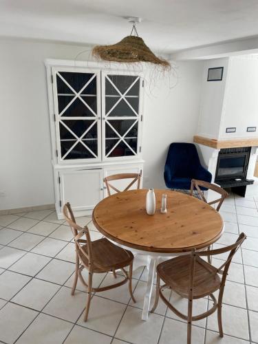 einen Holztisch und Stühle in einem Zimmer mit Küche in der Unterkunft La Blériotine in Sangatte