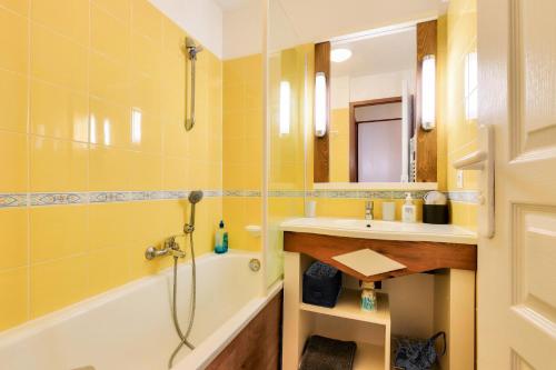 une salle de bain jaune avec un lavabo et une douche dans l'établissement Résidence Port Bourgenay - maeva Home - Appartement 2 pièces 4 personnes - Sélection MAE-6424, à Talmont-Saint-Hilaire