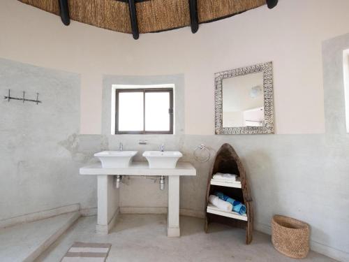 a bathroom with two sinks and a mirror at Masumu River Lodge in Binga