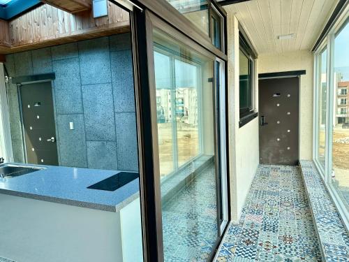 a room with glass doors and a tile floor at Fullhouse 6TO10 in Gangneung