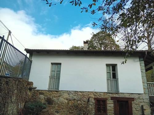 uma casa branca com duas janelas e uma cerca em Wonderful Rural House Lena 