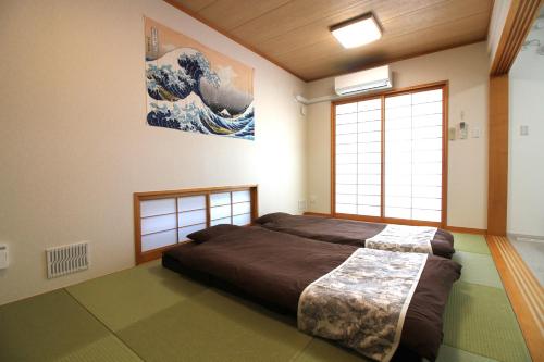 - une chambre avec un lit et une peinture murale dans l'établissement Sea Breeze Sumuide 沖縄, à Nago