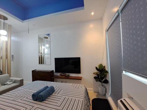 a bedroom with a bed with a blue ceiling at Hailey's Crib @ Azure North in San Fernando