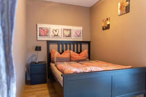 1 dormitorio con 1 cama con almohadas de color naranja en Ferienwohnung mit Balkon und zwei Schlafzimmern en Weißenstadt