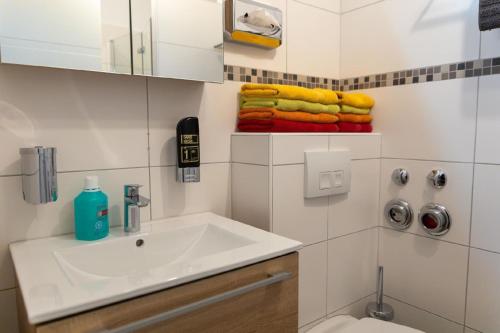 een badkamer met een wastafel, een toilet en handdoeken bij Ferienwohnung mit Balkon und zwei Schlafzimmern in Weißenstadt