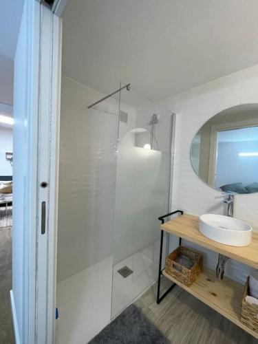 a white bathroom with a sink and a mirror at Apartamento Casa Cesárea in Cedeira