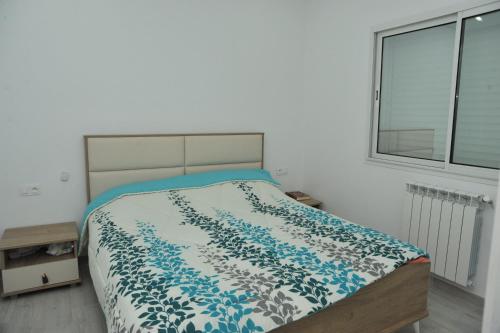 1 dormitorio con 1 cama con edredón azul y blanco en VILLA DE LUXE KANTAOUI SOUSSE en Hammam Sousse