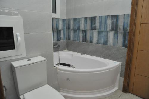 La salle de bains est pourvue de toilettes blanches et d'une baignoire. dans l'établissement VILLA DE LUXE KANTAOUI SOUSSE, à Hammam Sousse