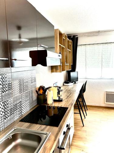 une cuisine avec un évier et un plan de travail dans l'établissement Studio MAJA proche des plages + parking, à Saint-Nazaire