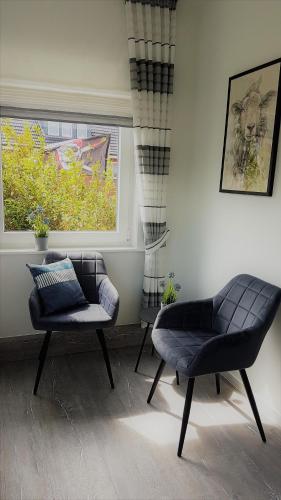 a living room with a couch and a chair and a window at Haus Mira in Wittdün