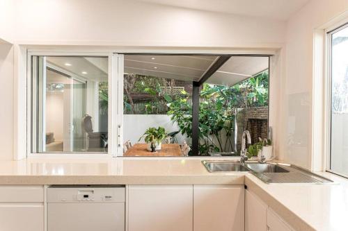 a kitchen with a sink and a large mirror at Villa Ohana Pono Luxury Family Home in Sunshine in Sunshine Beach