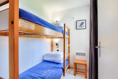 - une chambre avec 2 lits superposés et des draps bleus dans l'établissement Résidence Port Bourgenay - maeva Home - Appartement 3 pièces 5 personnes - Sélection MAE-9191, à Talmont-Saint-Hilaire