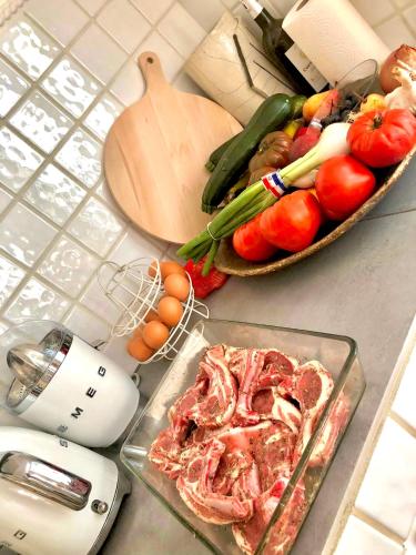 a counter with vegetables and a mixer and a plate of meat at Villa provençale Golfe St Tropez climatisée piscine chauffée, Spa, billard, Wifi haut débit pro in Gassin