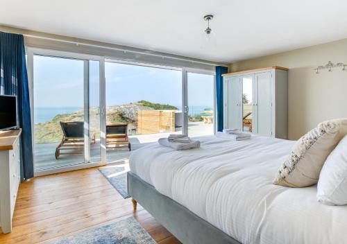 a bedroom with a large bed with a view of the ocean at Pencarreg in Polruan