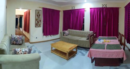 a living room with purple curtains and a couch and a table at Lushoto views homestays in Lushoto