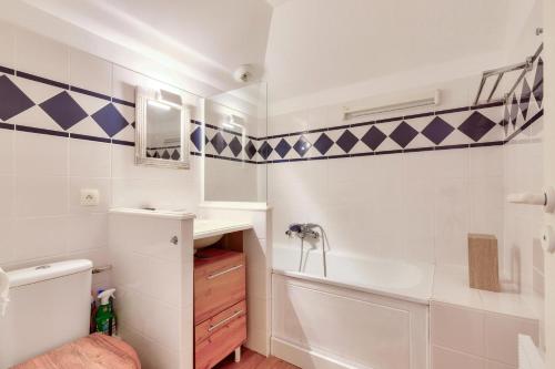 een badkamer met een bad, een wastafel en een toilet bij Les Maisons de Port Bourgenay - maeva Home - Maison 4 pièces 8 personnes - 291 in Talmont