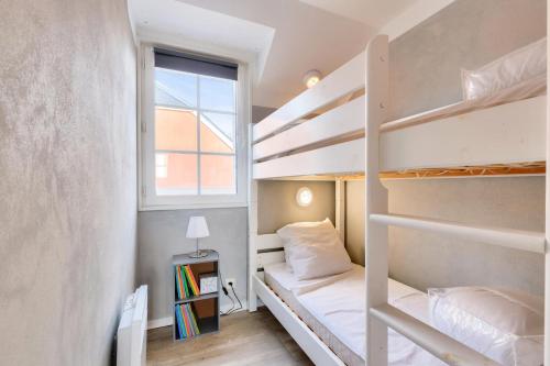 een kleine slaapkamer met een stapelbed en een raam bij Les Maisons de Port Bourgenay - maeva Home - Maison 4 pièces 8 personnes - 291 in Talmont