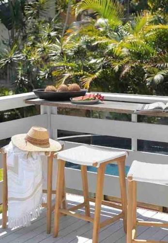 a table with two chairs and a hat on it at The Lodge Noosa ~ Coastal Luxe in Noosas Heart in Noosa Heads