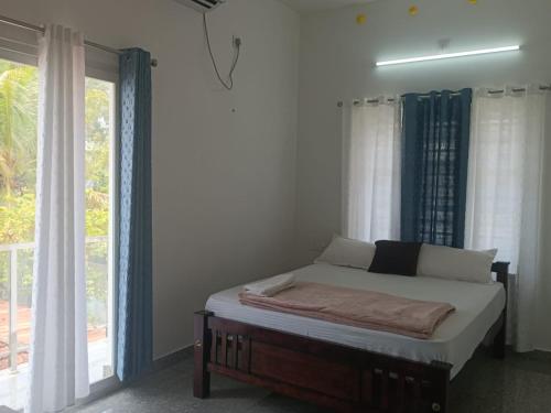 a bed in a room with a large window at Alleppy Whitefort Homestay Dulux Rooms -HouseBoat Available in Alleppey